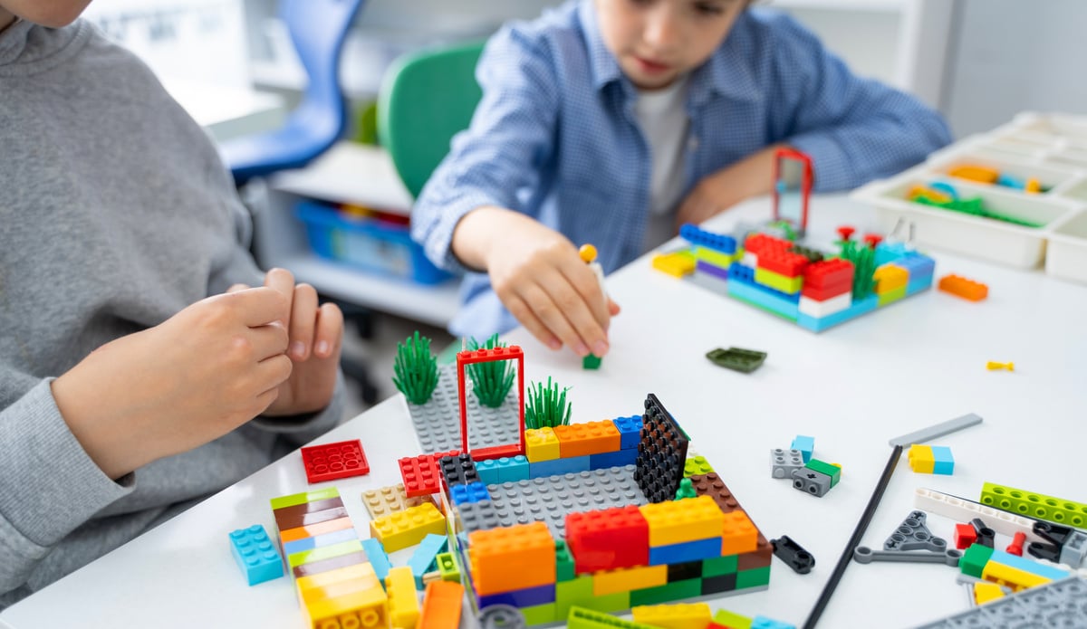 Robotics lego programming class. Children construct and code Robot Lego. STEM education using constructor blocks and laptop, remote control joystick. Technology educational development for school kids. Advertisement copy space